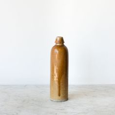 a brown vase sitting on top of a white counter