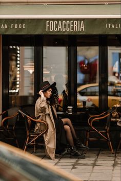 a woman sitting on a chair in front of a restaurant