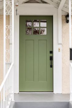 a green front door on a house with white trim