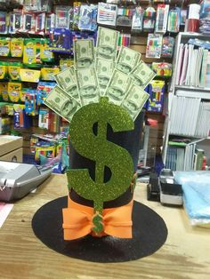 a dollar sign is sitting on top of a hat with money sticking out of it