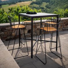 two chairs and a table sitting on top of a stone patio