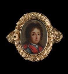 an antique gold ring with a portrait of a man in red and blue clothes on it