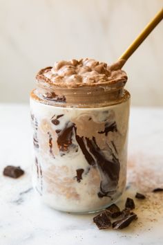 a jar filled with chocolate and marshmallows sitting on top of a table