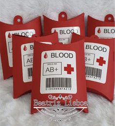 four red blood bags with barcodes are on a white furnishing area