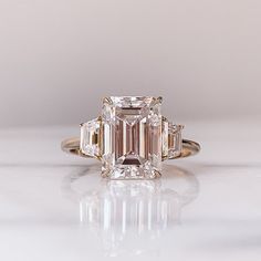 an emerald cut diamond ring with three baguets