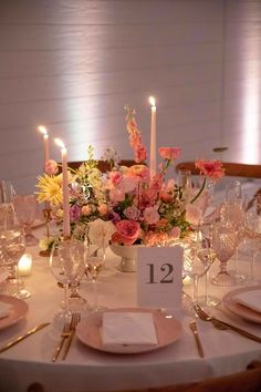 the table is set with flowers and candles for an elegant wedding reception or special event