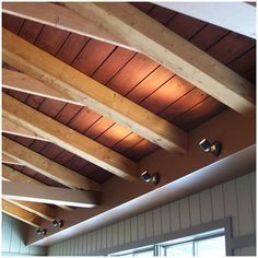 the ceiling is covered with wood planks and has three lights on each side of it