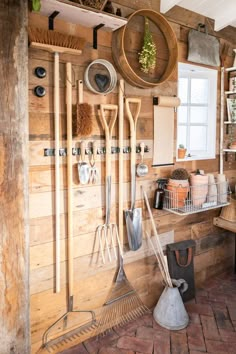 a kitchen with wooden walls and lots of utensils hanging on the wall next to it