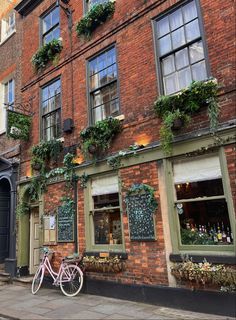 A building is covered with plants. A vintage pink bicycle is parked in front of the building. Tavern Ideas, Japanese Architecture, Architecture