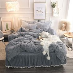 a bed with grey comforter and white pillows