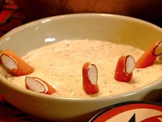 a white bowl filled with soup and toppings on top of a red table cloth