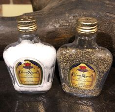 two bottles are sitting on a table next to each other, one is filled with sand and the other has sea salt in it