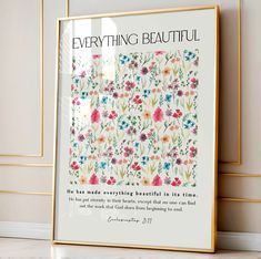 a framed poster with the words, everything beautiful and flowers on it in front of a white wall