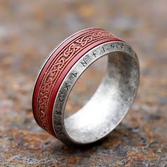 a silver ring with red inlays is on the ground and looks like it's made out of metal