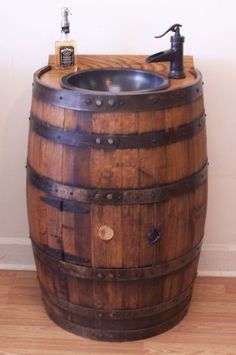 a wooden barrel with a sink and faucet in it sitting on top of a hard wood floor