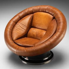 a brown leather chair sitting on top of a metal base