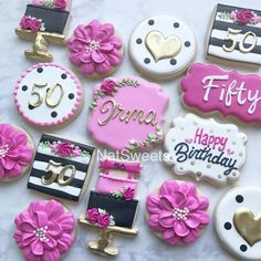 decorated cookies with pink and white frosting are arranged on a marble countertop in the shape of 50th