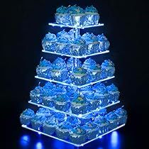 a very large blue christmas tree made out of plastic containers and lights in the dark