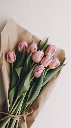 a bouquet of pink tulips tied with twine