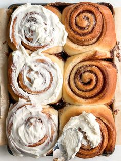 cinnamon rolls with cream cheese frosting in a baking pan