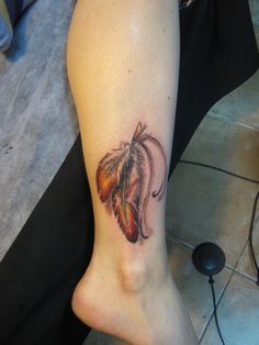 a woman's leg with a tattoo on it that has a flower in the center