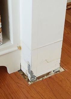 a cat is sitting on the floor next to a book shelf with books in it