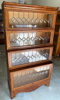 a wooden bookcase with glass inserts on top