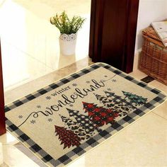 a welcome mat with christmas trees on it in the middle of a room next to a door