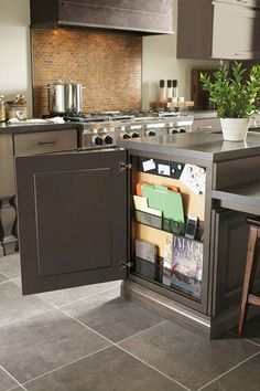 an open cabinet in the middle of a kitchen with magazines and papers on it's doors