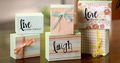 four small gift boxes with the word love written on them, sitting on a table