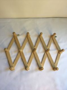 three wooden pegs are hanging on a white sheet with some sort of wall decoration