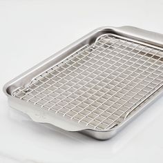 a stainless steel grate on a white surface