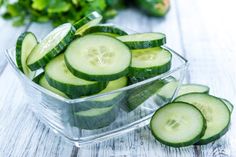 sliced cucumbers in a plastic container on a white table