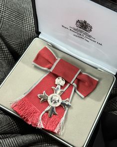 the medal is in its presentation box on top of some cloths, and it's attached to a tie