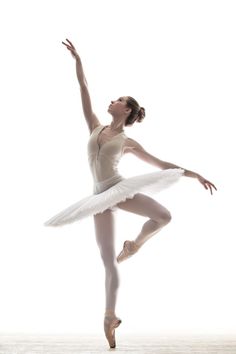 a ballerina in white is posing for the camera