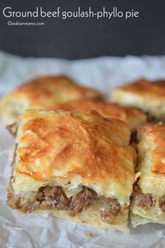 some meat and cheese pastries are sitting on wax paper with the words ground beef squash phyllo pie