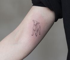 a small sheep tattoo on the arm