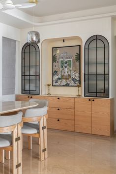 a dining room table with chairs and a painting on the wall in the back ground