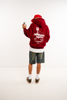 a boy in a red hoodie is holding a remote control