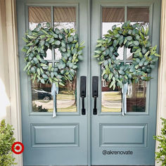 two wreaths on the front door of a house