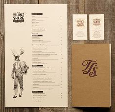 the menu and business cards are laid out next to each other on a wooden table