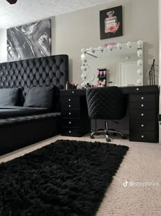 a black and white bedroom with a bed, desk, mirror and dresser in it