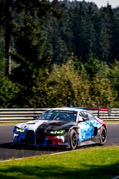 a car driving on a race track with trees in the backgrounds