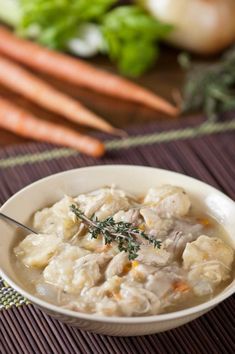 a white bowl filled with food next to carrots