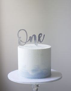 a white cake with the word one on top