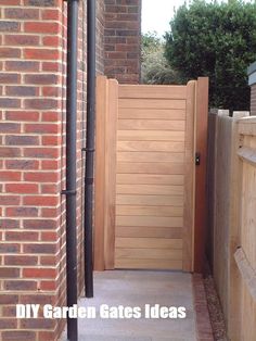 an open wooden door on the side of a brick building next to a sidewalk and fence