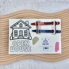 an open house card with crayons and markers