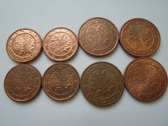 six different types of foreign coins on a white surface