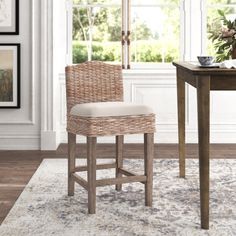 a wicker bar stool sits in front of a table