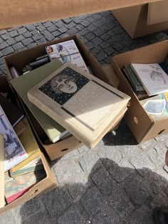 many books are sitting in boxes on the ground